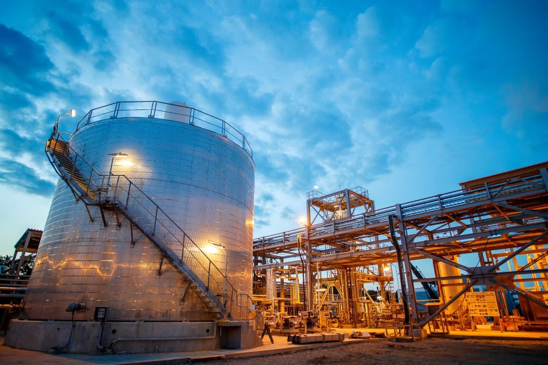 Gas storage facility illuminated at dusk
